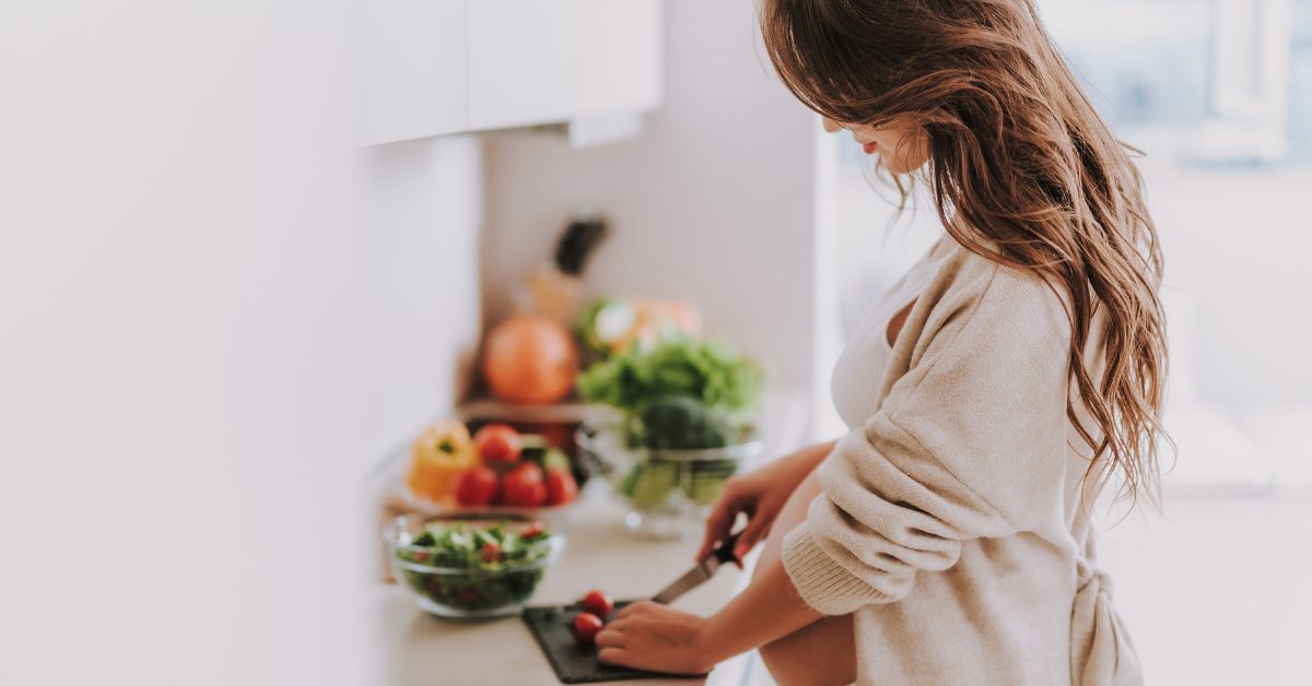 5 Mujer cocinando verduras en cocina blanca